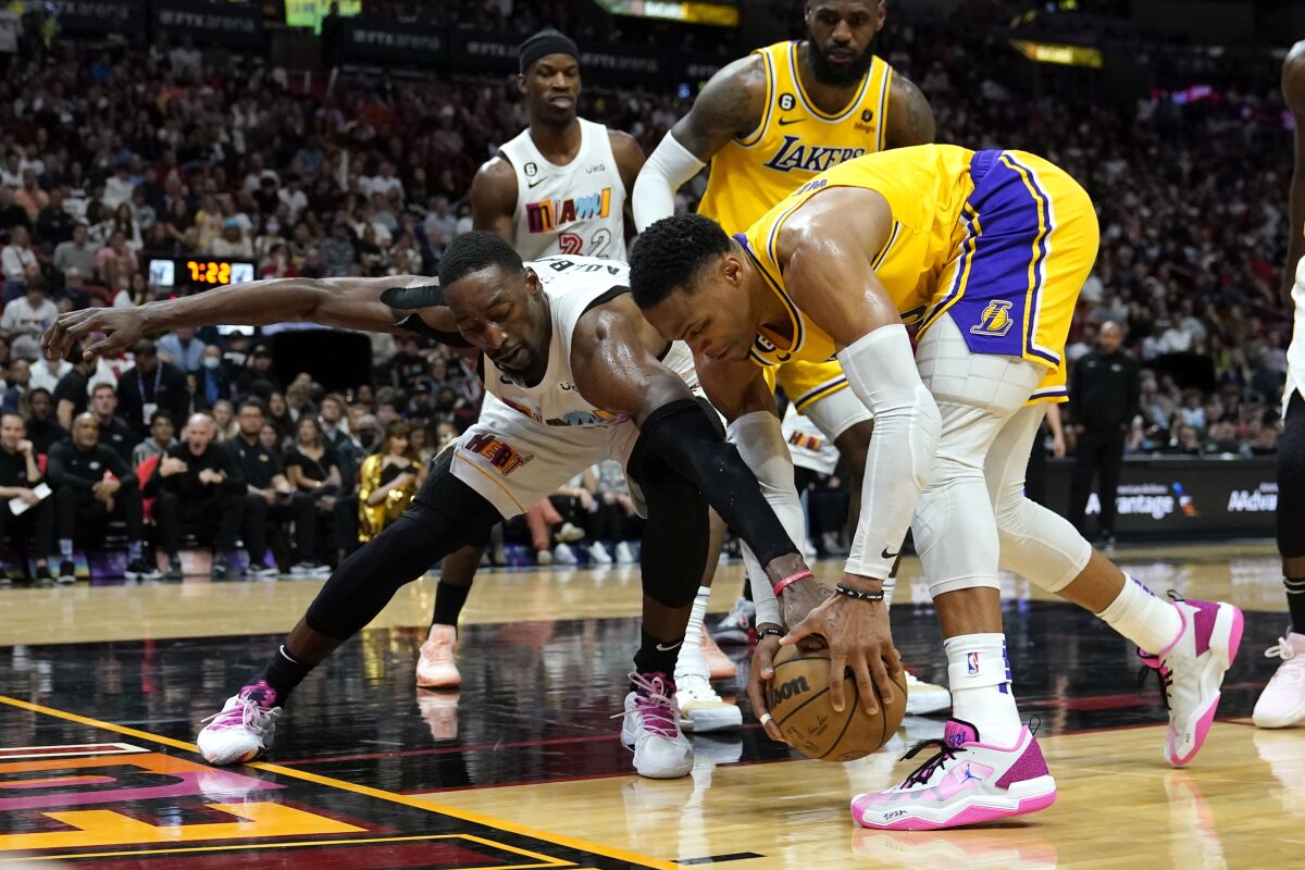 Miami Heat center Bam Adebayo and Lakers guard Russell Westbrook go for the ball.